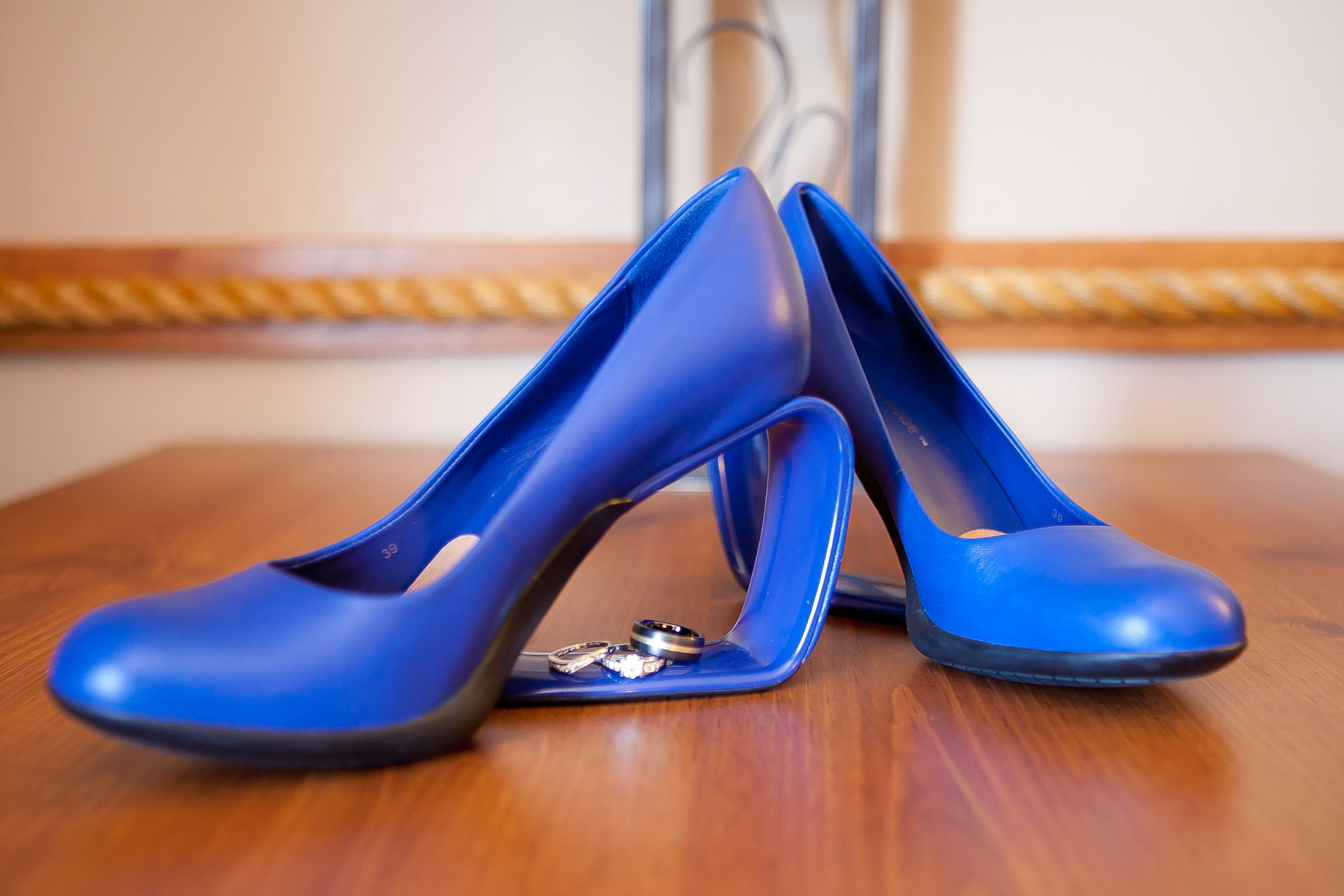 Cobalt blue United Nude Möbius-heel pumps — the bride's something blue — photographed with the wedding rings nested in the heel loop
